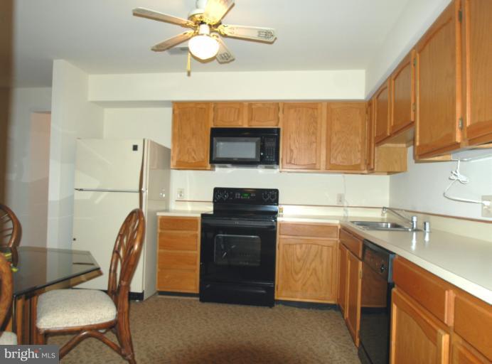 984 Riversedge Circle Annapolis, MD 21401 - Photo 13 of 14 a kitchen with stainless steel appliances granite countertop a stove top oven a sink a dining table and chairs with wooden floor