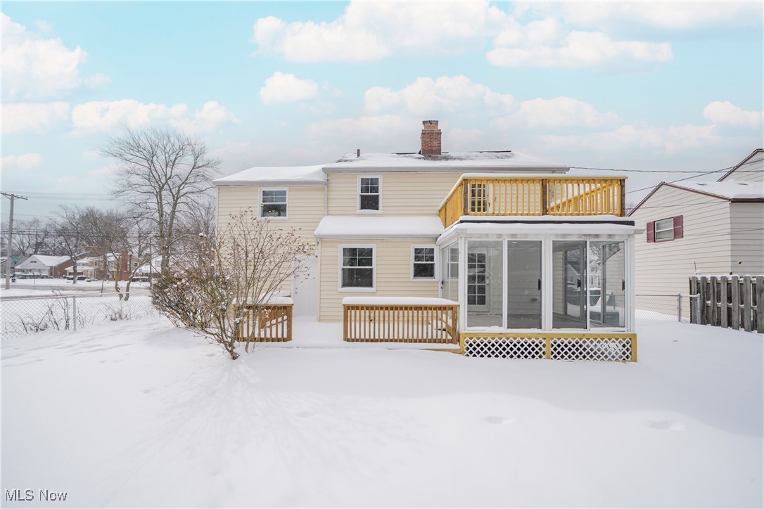 2279 North Taylor Road Cleveland, OH 44112 - Photo 34 of 35 Snow covered rear of property featuring a deck, a sunroom, and fence