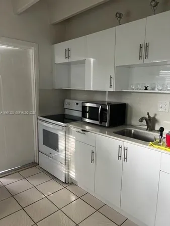 a kitchen with cabinets stainless steel appliances and sink