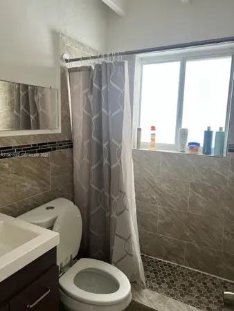 a bathroom with a toilet a sink and a shower