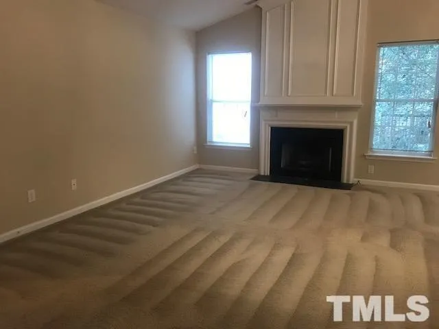 a view of empty room with a fireplace