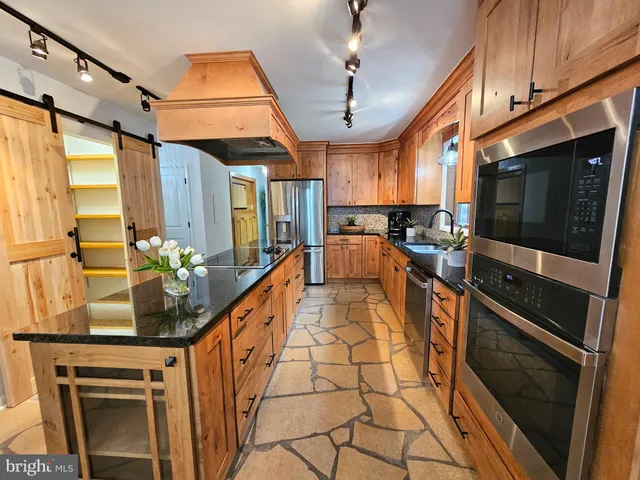 an empty room with wooden floor cabinet and windows