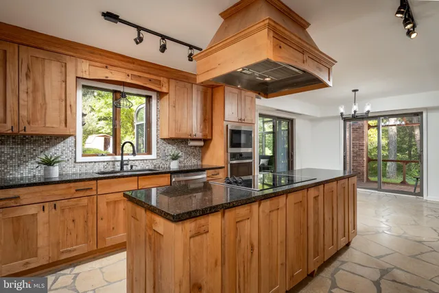 a kitchen with stainless steel appliances granite countertop a sink and a large window
