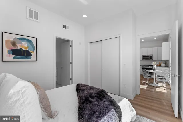 a bedroom with a bed and a view of kitchen