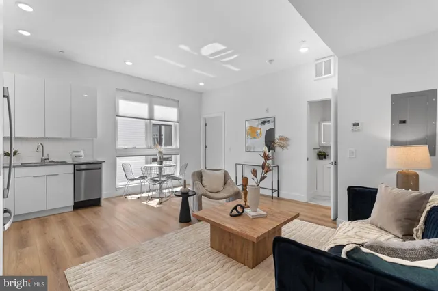 a living room with furniture and view of kitchen