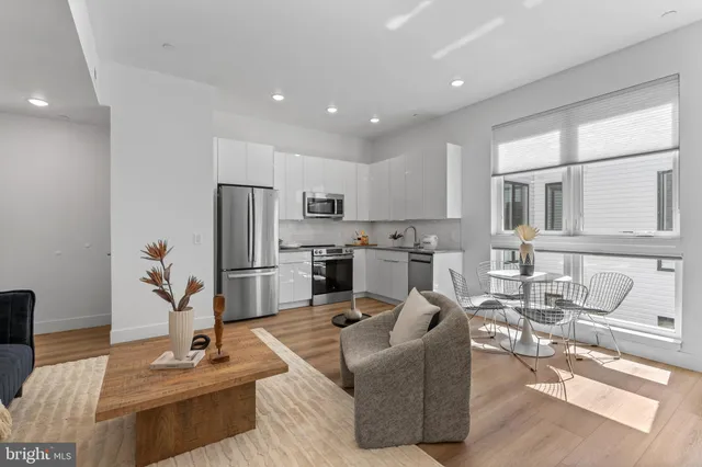 a living room with furniture wooden floor and a view of kitchen