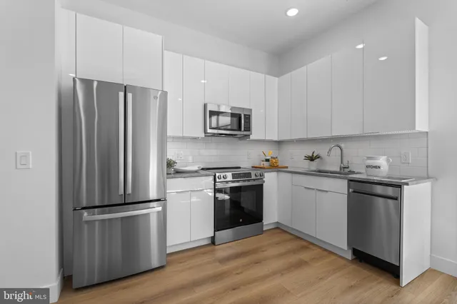 a kitchen with granite countertop stainless steel appliances and wooden cabinets