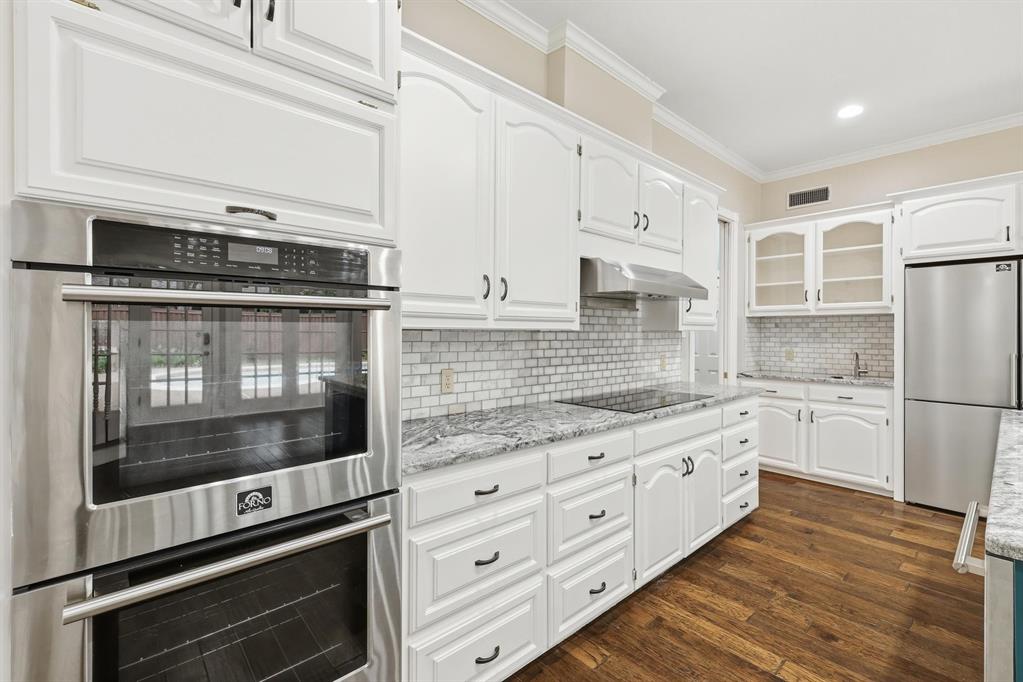 848 Birdsong Bedford, TX 76021 - Photo 10 of 40 a kitchen with granite countertop cabinets stainless steel appliances and wooden floor