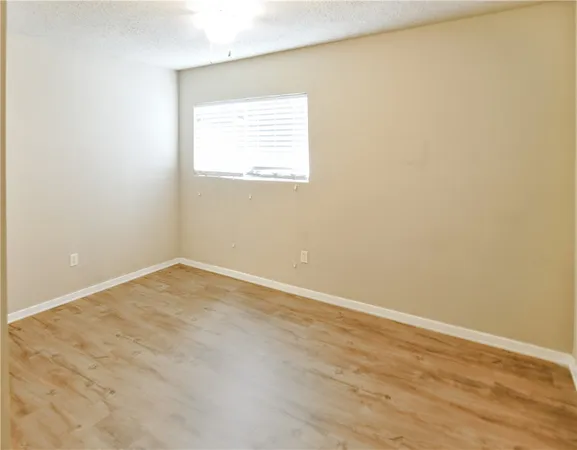 an empty room with wooden floor and a window