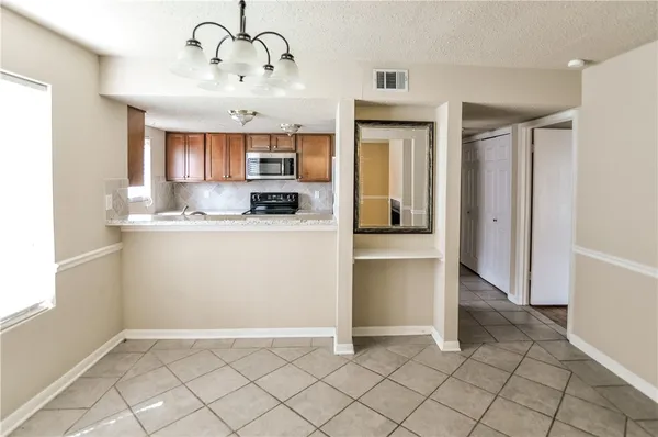 a kitchen with kitchen island granite countertop a refrigerator and a sink