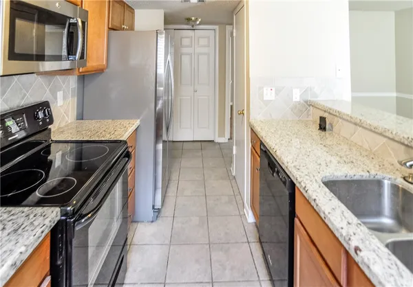 a kitchen with a sink stove top oven and cabinets
