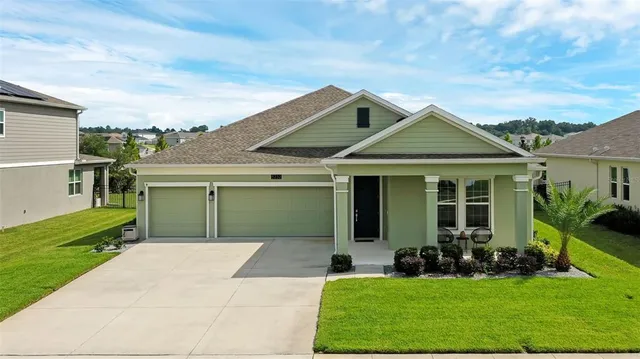 a front view of a house with a yard and potted plants