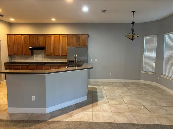 a kitchen with kitchen island a counter top space cabinets and stainless steel appliances