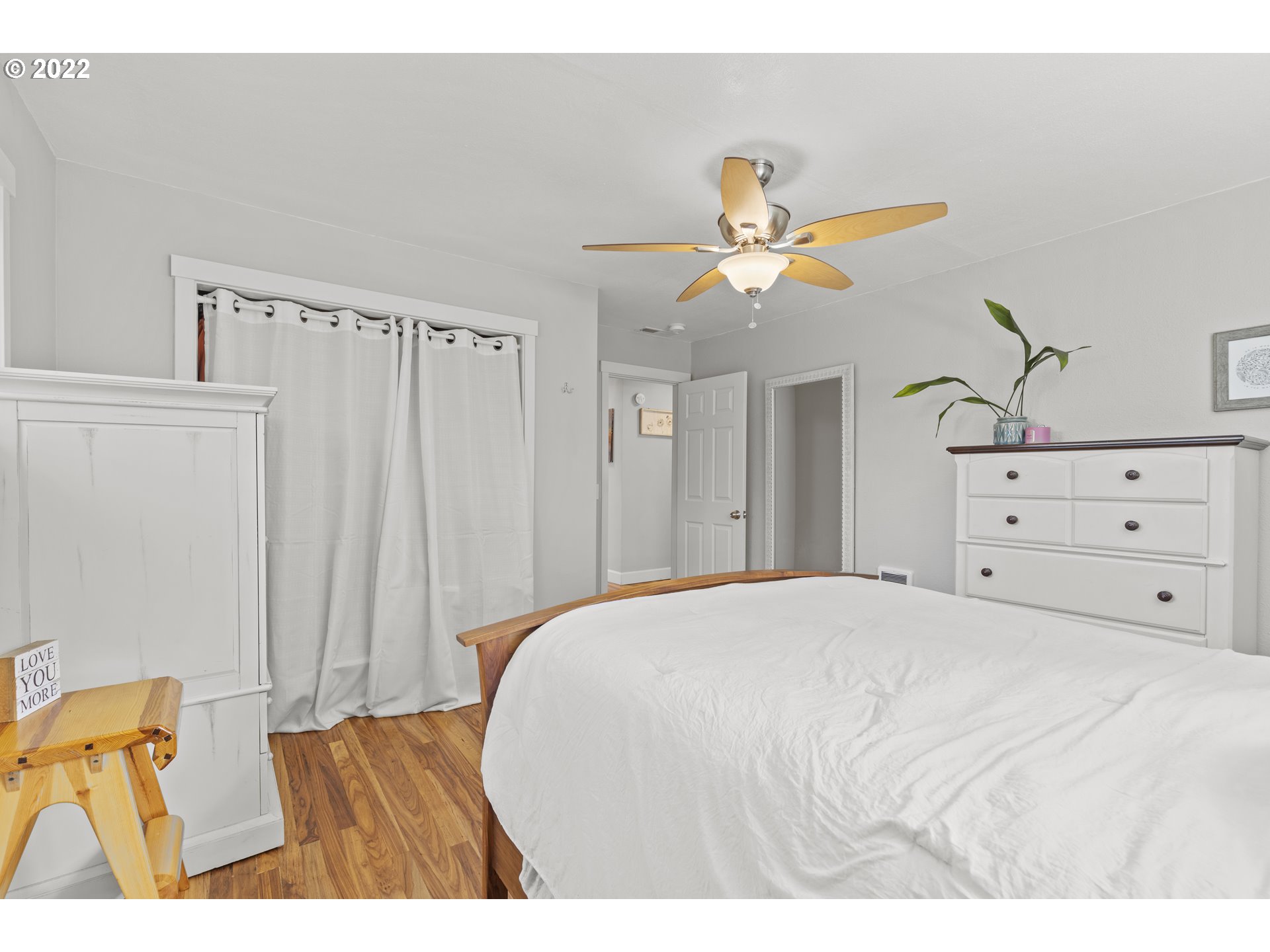 1174 Southwest Maple Street Dallas, OR 97338 - Photo 15 of 32 a bedroom with a bed a dresser and a chandelier