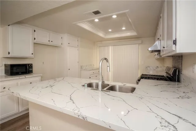 a kitchen with granite countertop a stove and a sink