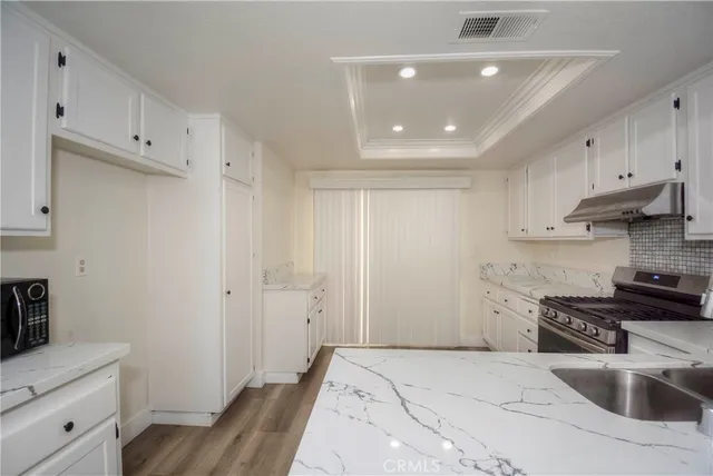 a kitchen with granite countertop a stove and a sink