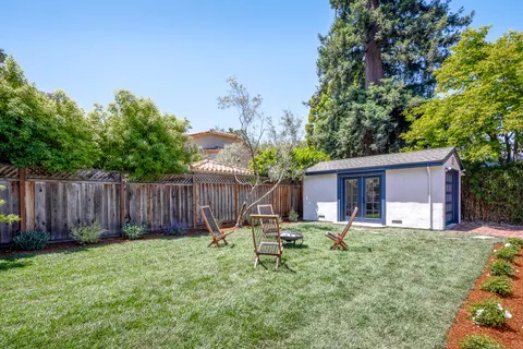 a backyard of a house with table and chairs