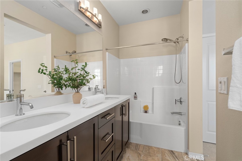 12913 Mission Hawthorne Ca, Unit 108 Hawthorne, CA 90250 - Photo 20 of 31 a bathroom with a granite countertop sink a mirror a bathtub and shower