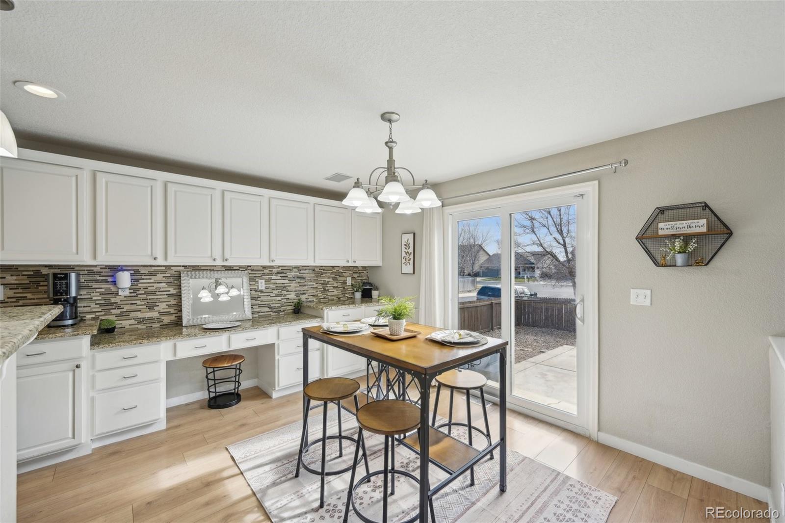 591 Rio Rancho Way Brighton, CO 80601 - Photo 16 of 47 a kitchen with a dining table cabinets and stainless steel appliances