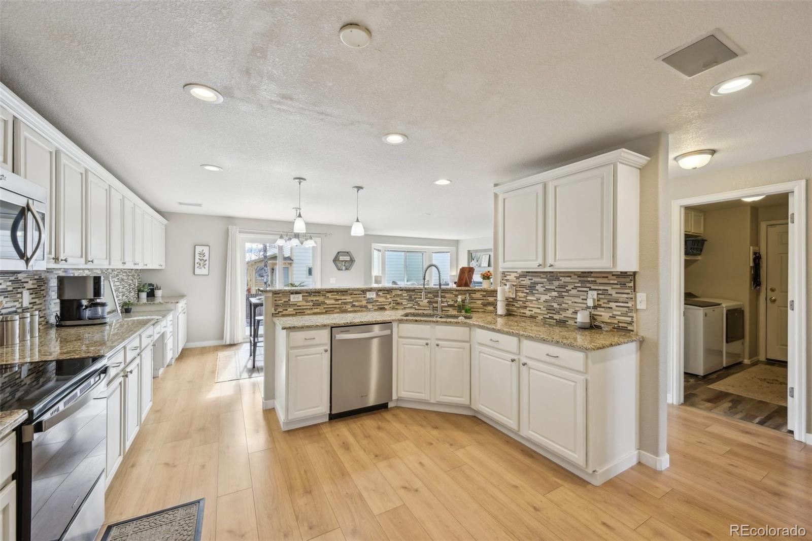 591 Rio Rancho Way Brighton, CO 80601 - Photo 18 of 47 a kitchen with stainless steel appliances granite countertop a stove top oven a sink dishwasher and a refrigerator