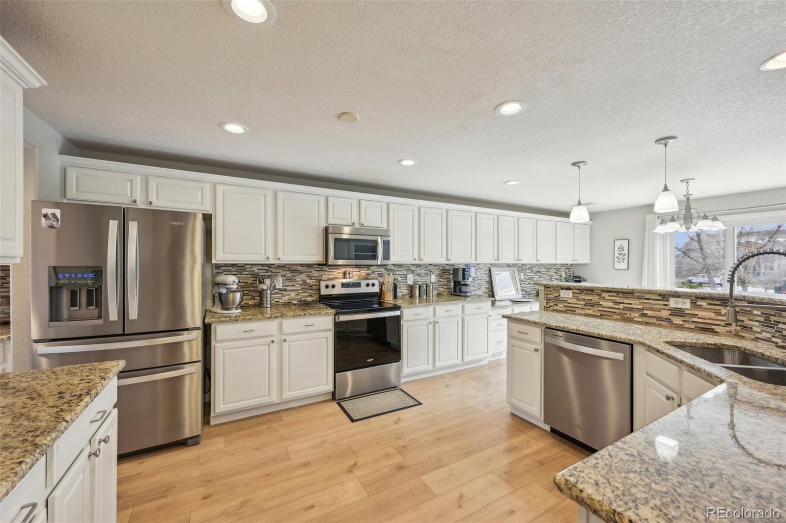591 Rio Rancho Way Brighton, CO 80601 - Photo 19 of 47 a kitchen with stainless steel appliances granite countertop a stove top oven a sink and a refrigerator