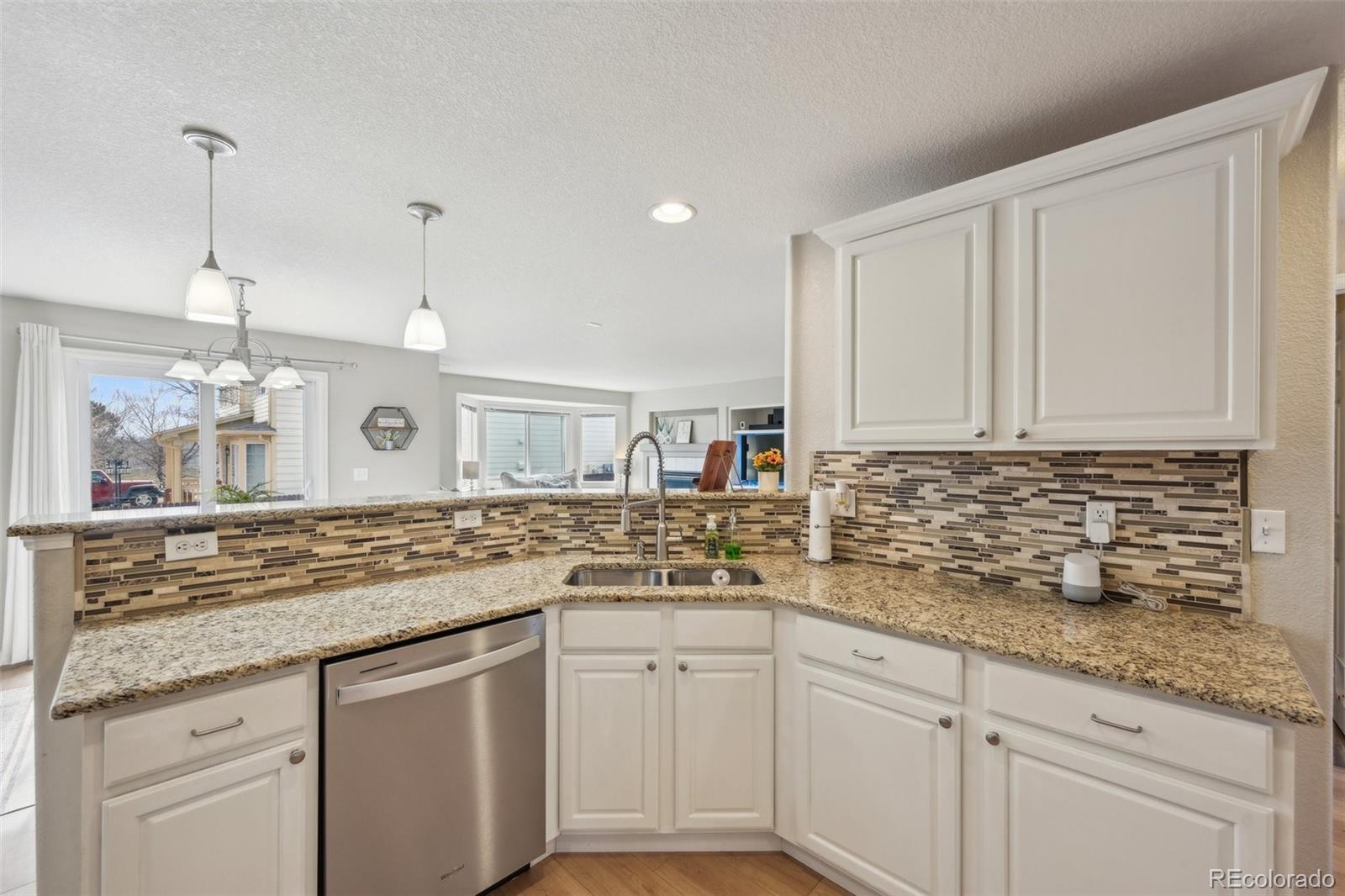 591 Rio Rancho Way Brighton, CO 80601 - Photo 20 of 47 a kitchen with granite countertop a sink and cabinets
