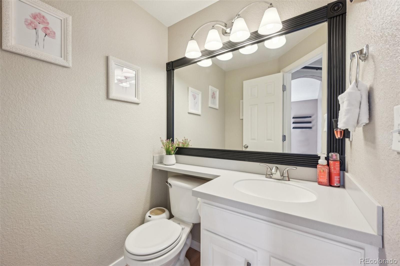 591 Rio Rancho Way Brighton, CO 80601 - Photo 23 of 47 a bathroom with a sink vanity mirror and toilet