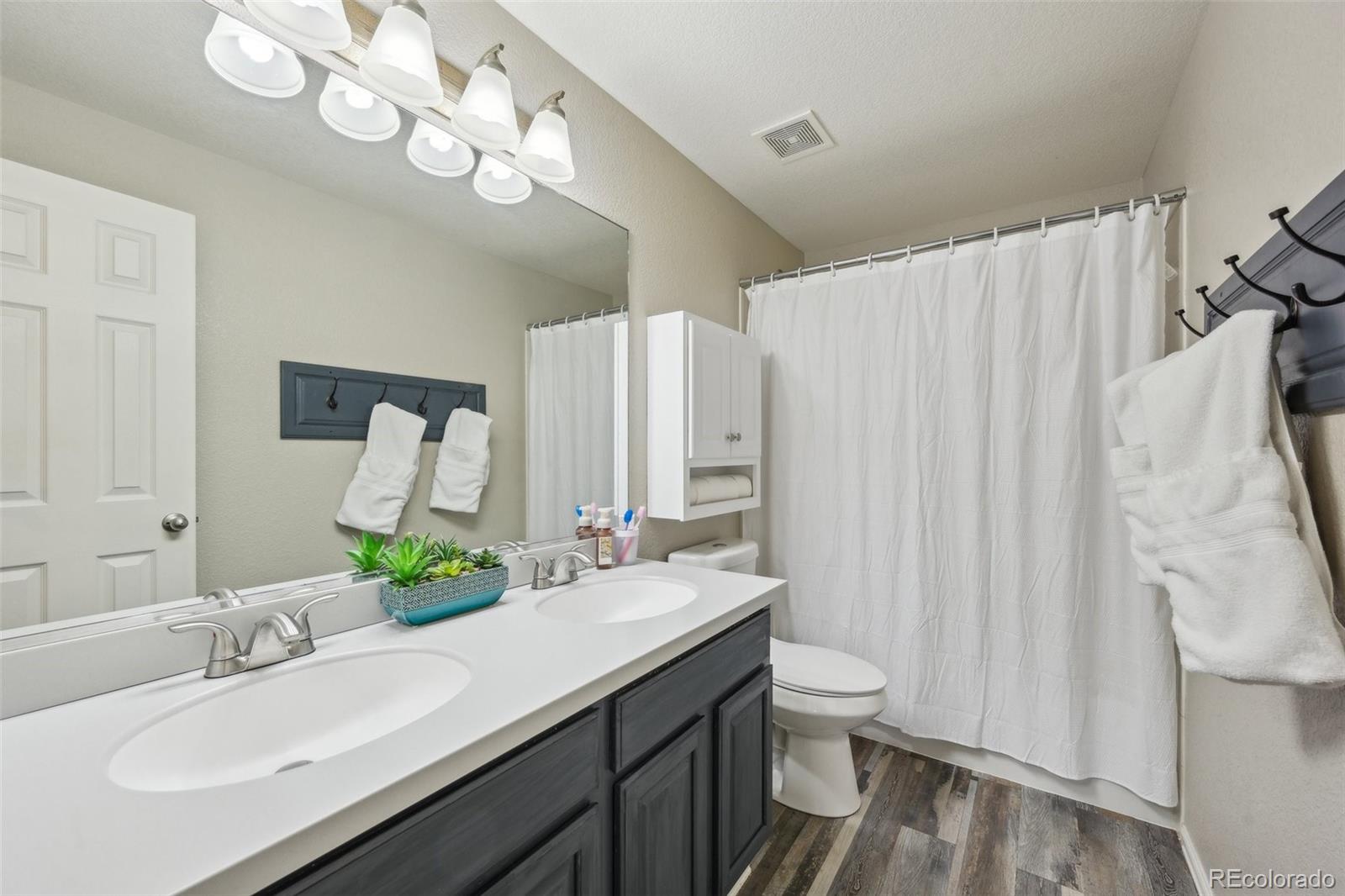 591 Rio Rancho Way Brighton, CO 80601 - Photo 33 of 47 a bathroom with a double vanity sink and a mirror