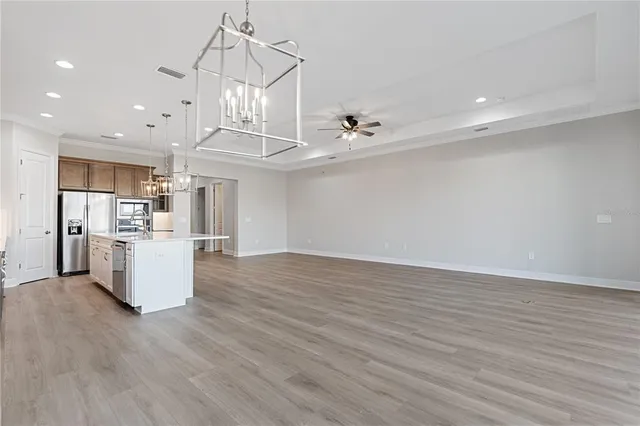 a view of kitchen with stainless steel appliances a refrigerator and wooden floor