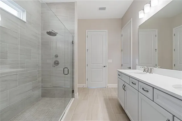 a spacious bathroom with a shower sink and mirror