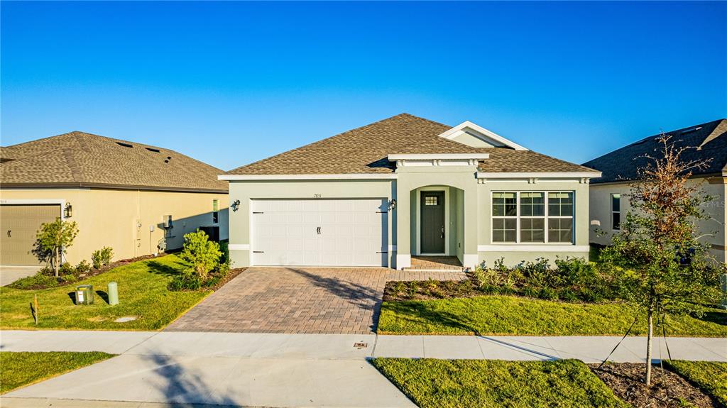 7851 Stoney Bay Loop Kissimmee, FL 34747 - Photo 20 of 33 a front view of a house with a garden