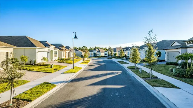 an aerial view of a residential houses with outdoor space and street view