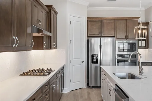 a kitchen with stainless steel appliances granite countertop a sink stove and refrigerator
