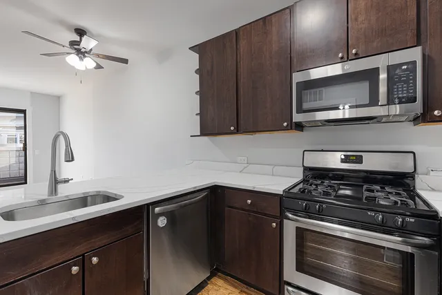a kitchen with stainless steel appliances a stove a microwave and sink