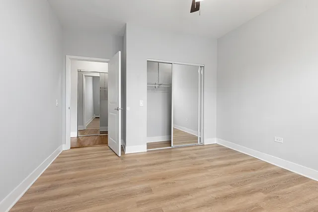 an empty room with wooden floor and bathroom