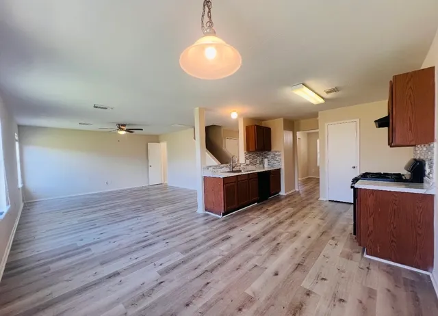 a large kitchen with stainless steel appliances kitchen island a large counter top and a wooden floors