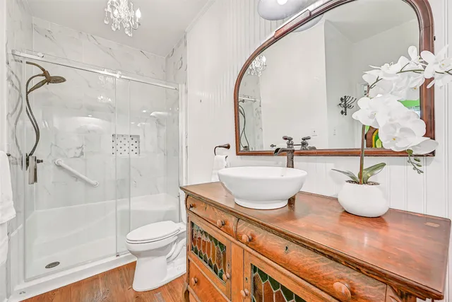 a bathroom with a granite countertop sink a toilet and shower