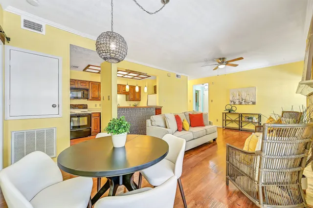 a living room with furniture a chandelier and a dining table