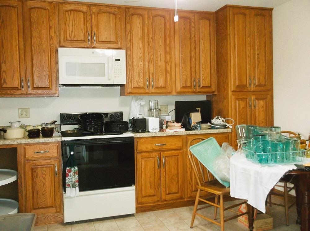 2794 South Union Road Polo, IL 61064 - Photo 3 of 32 a kitchen with stainless steel appliances granite countertop a stove a sink dishwasher and a microwave oven with wooden cabinets