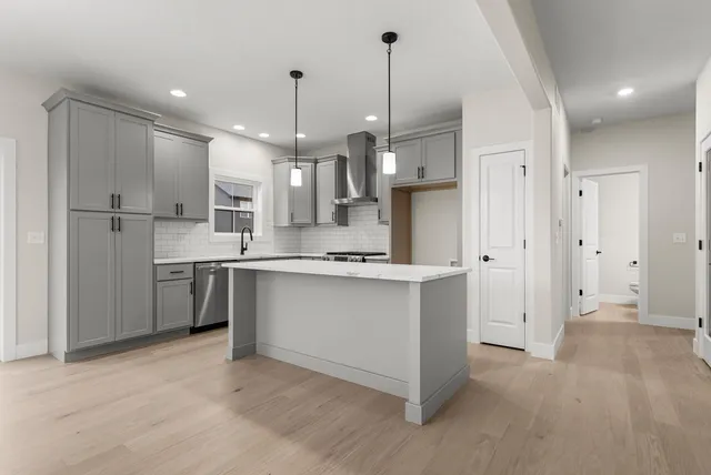 a kitchen with stainless steel appliances kitchen island a refrigerator sink and cabinets