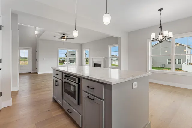 a kitchen with stainless steel appliances granite countertop a sink a stove and a wooden floors