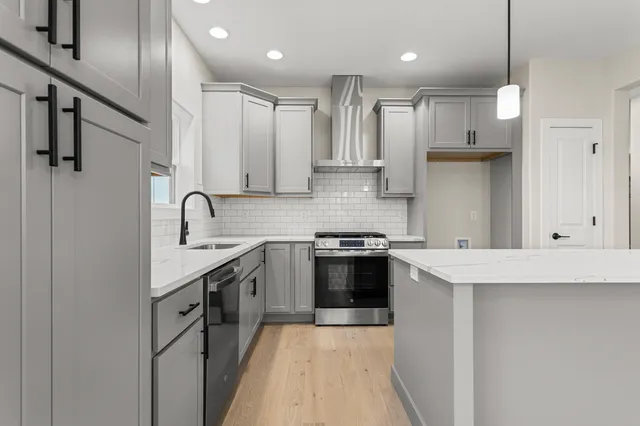 a kitchen with stainless steel appliances granite countertop a sink stove and refrigerator
