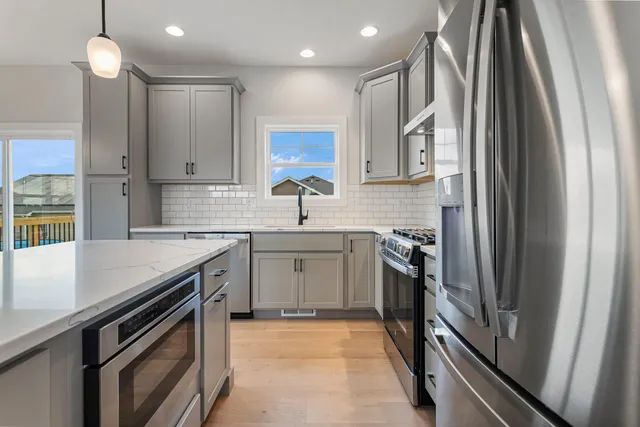 a kitchen with stainless steel appliances granite countertop a sink and a stove top oven