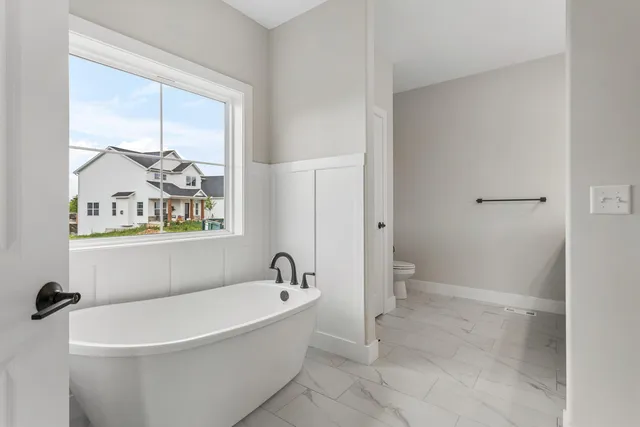 a white bath tub sitting next to a toilet