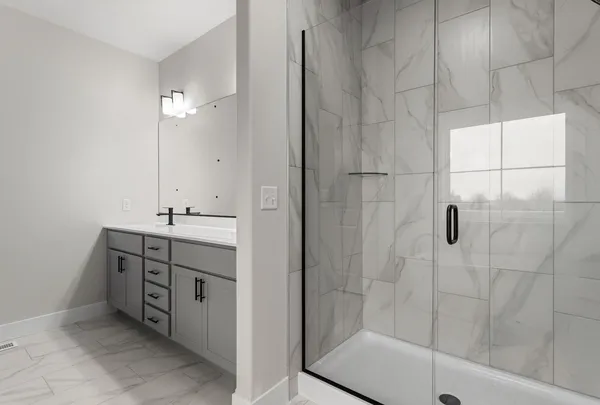 a bathroom with a double vanity sink a toilet and shower