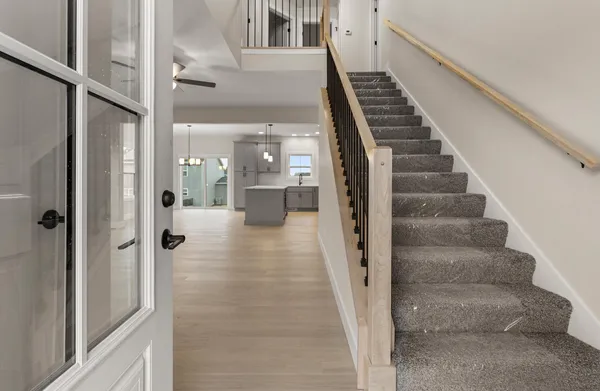a view of a hallway with wooden floor and staircase