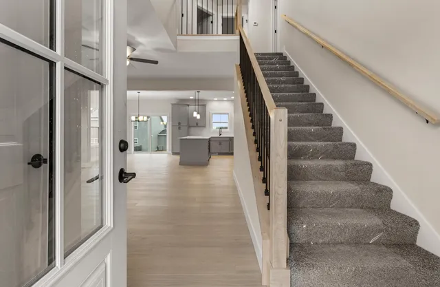 a view of a hallway with wooden floor and staircase