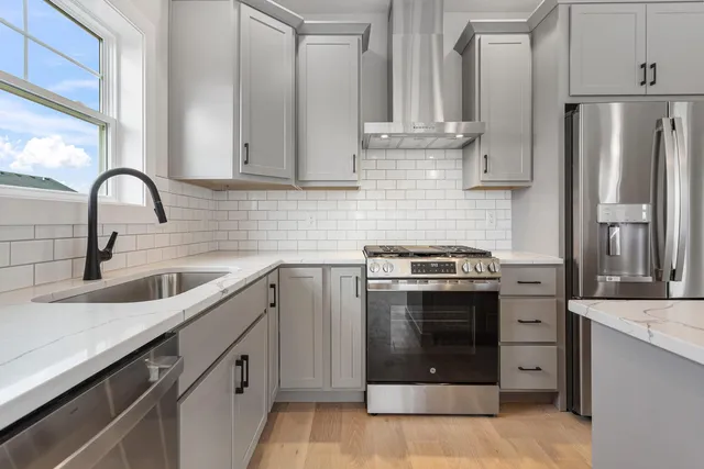 a kitchen with stainless steel appliances granite countertop a sink stove and refrigerator