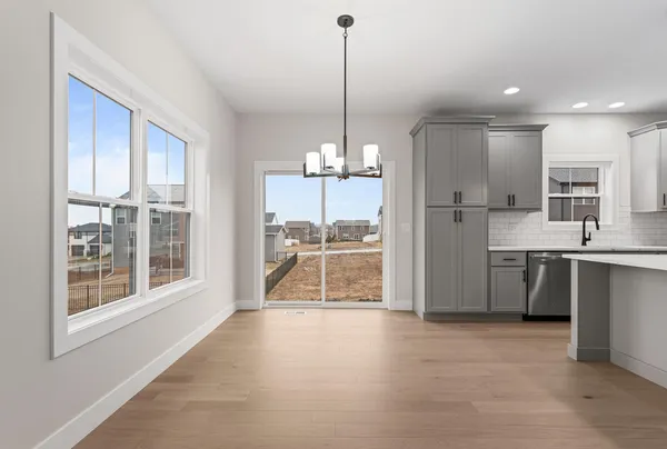 a view of a kitchen with kitchen island a large counter top stainless steel appliances and cabinets