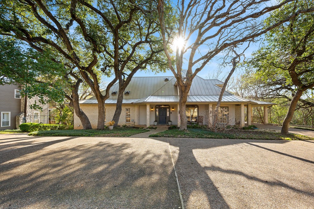 a front view of a house with a yard and trees